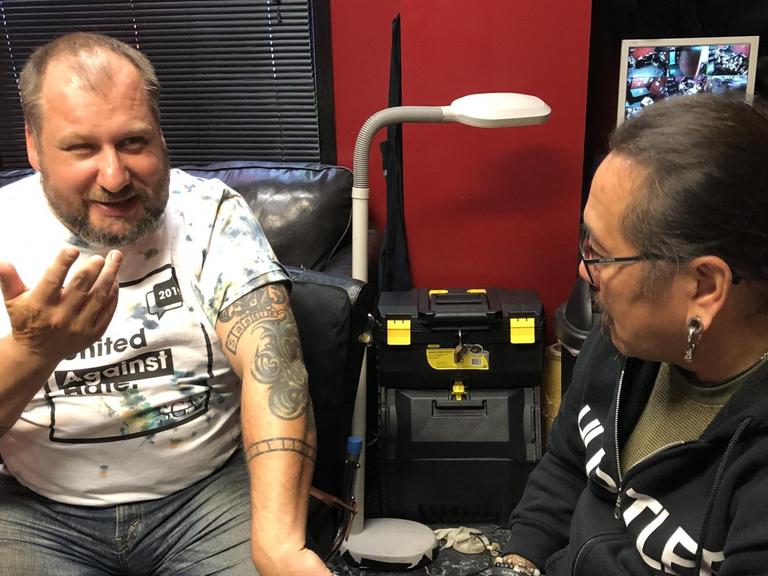 Ex-Neonazi TM Garret Schmid (links) mit Tattoo-Künstler Jack Flores. Mit ihrer Organisation "Erasing the hate" helfen sie Aussteigern aus der Extremisten-Szene - auch praktisch beim Loswerden ihrer Hass-Tattoos.