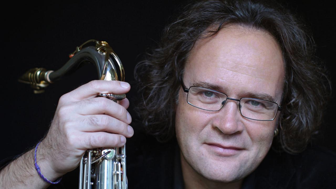 Porträt von Peter Weniger mit seinem Saxofon in der Hand