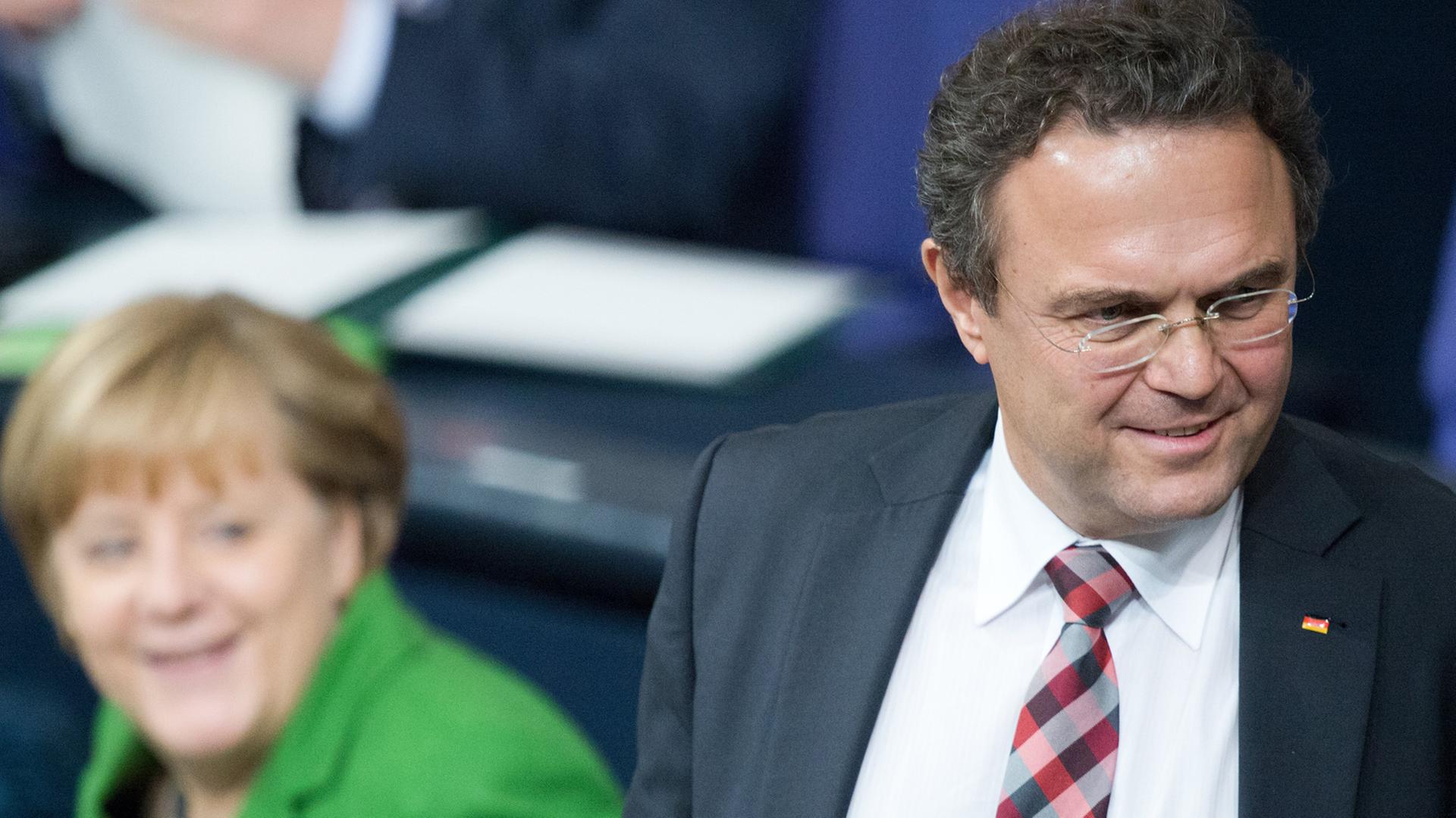 Hans-Peter Friedrich steht vor der Regierungsbank im Bundestag, hinter ihm sitzt Bundeskanzlerin Angela Merkel. Hans-Peter Friedrich steht vor der Regierungsbank im Bundestag, hinter ihm sitzt Bundeskanzlerin Angela Merkel.