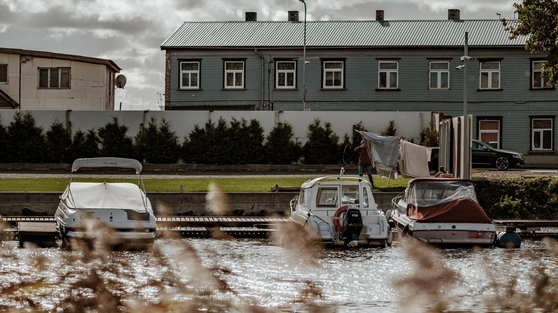 Herbstliche Ansicht aus dem estnischen Ferienort Pärnu: Hauser, Motorboote und eine Limousine Herbstliche Ansicht aus dem estnischen Ferienort Pärnu: Hauser, Motorboote und eine Limousine