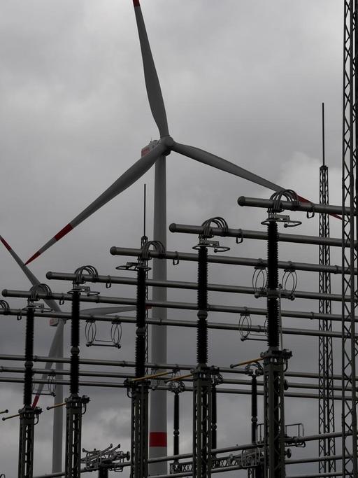 Eine Windkraftanlage hinter einem Umspannwerk.