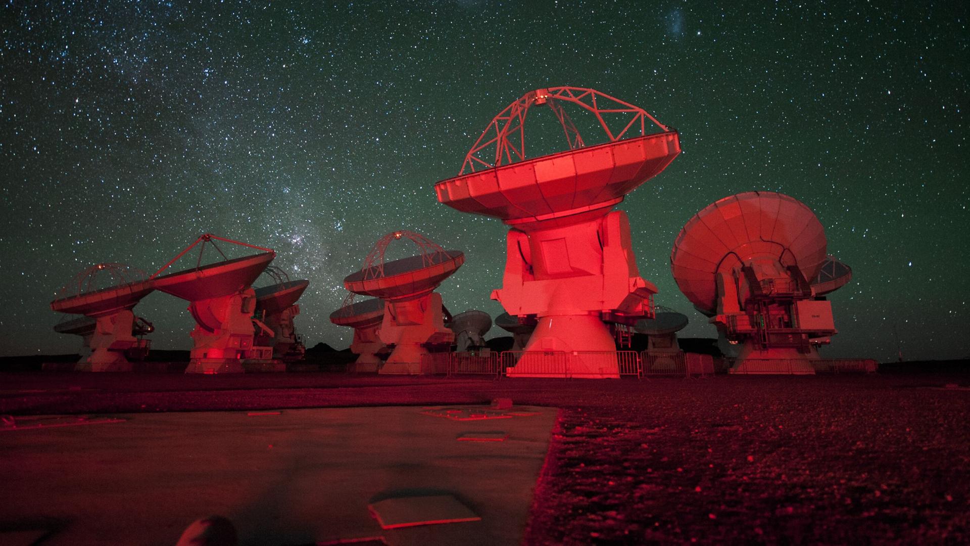 Die Große (links) und Kleine Magellansche Wolke über der ALMA-Teleskopanlage im Norden Chiles