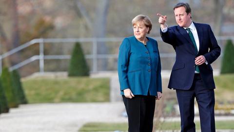 Der britische Premier David Cameron diskutiert mit Bundeskanzlerin Angela Merkel im Garten von Schloss Meseberg bei Berlin.