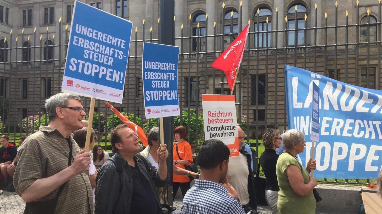 Die Demonstranten stehen an einem Zaun vor dem Bundesratsgebäude und halten Transparente und Schilder in die Höhe. Auf einem Schild steht: "Ungerechte Erbschaftssteuerreform stoppen!" Die Demonstranten stehen an einem Zaun vor dem Bundesratsgebäude und halten Transparente und Schilder in die Höhe. Auf einem Schild steht: "Ungerechte Erbschaftssteuerreform stoppen!"