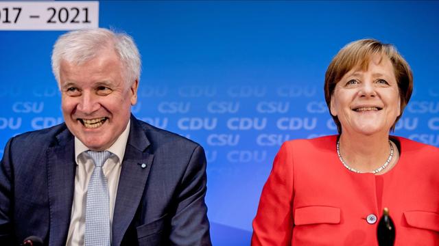 CDU-Chefin Merkel und CSU-Chef Seehofer lachen in die Kamera