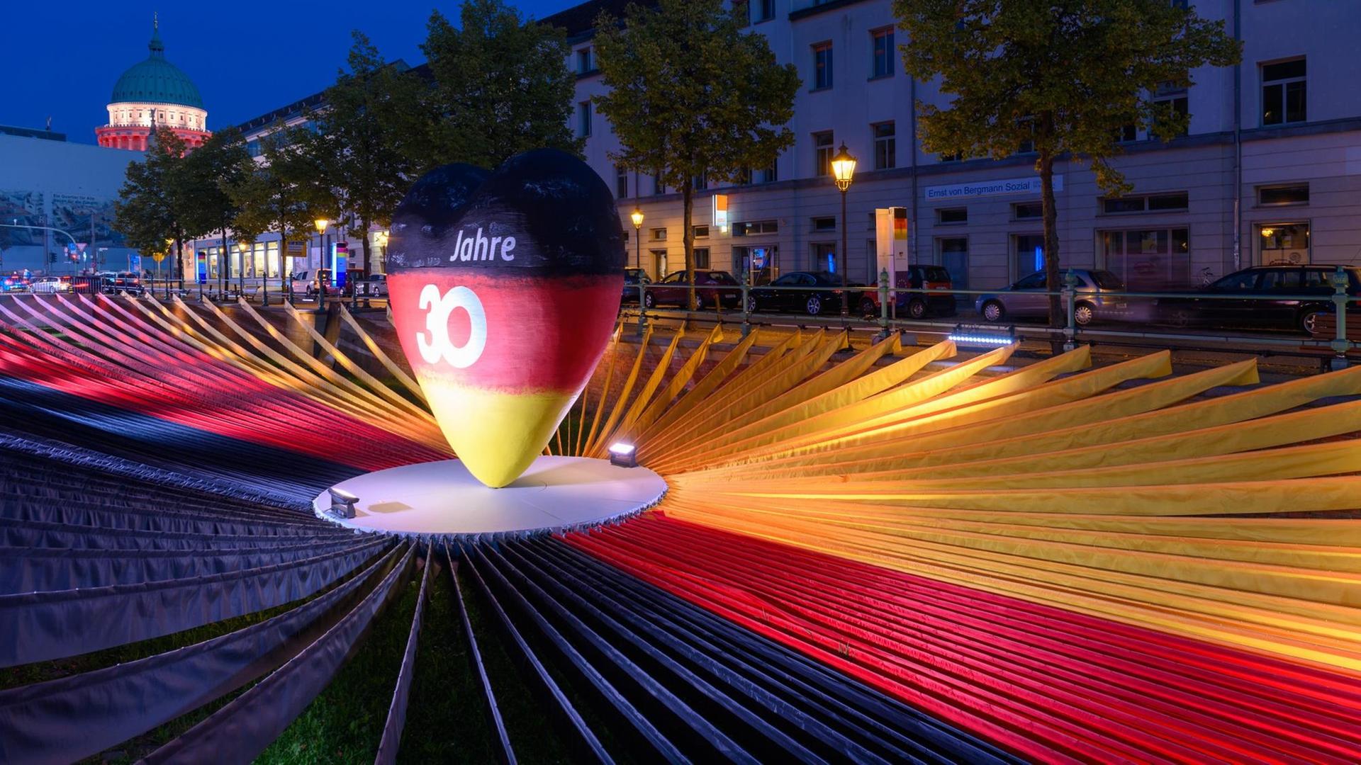 Ein schwarz-rot-goldenes Herz steht in der Ausstellung "Weg zur Einheit" im Rahmen der EinheitsEXPO im Mittelpunkt von schwarzen, roten und gelben Stoffbahnen.