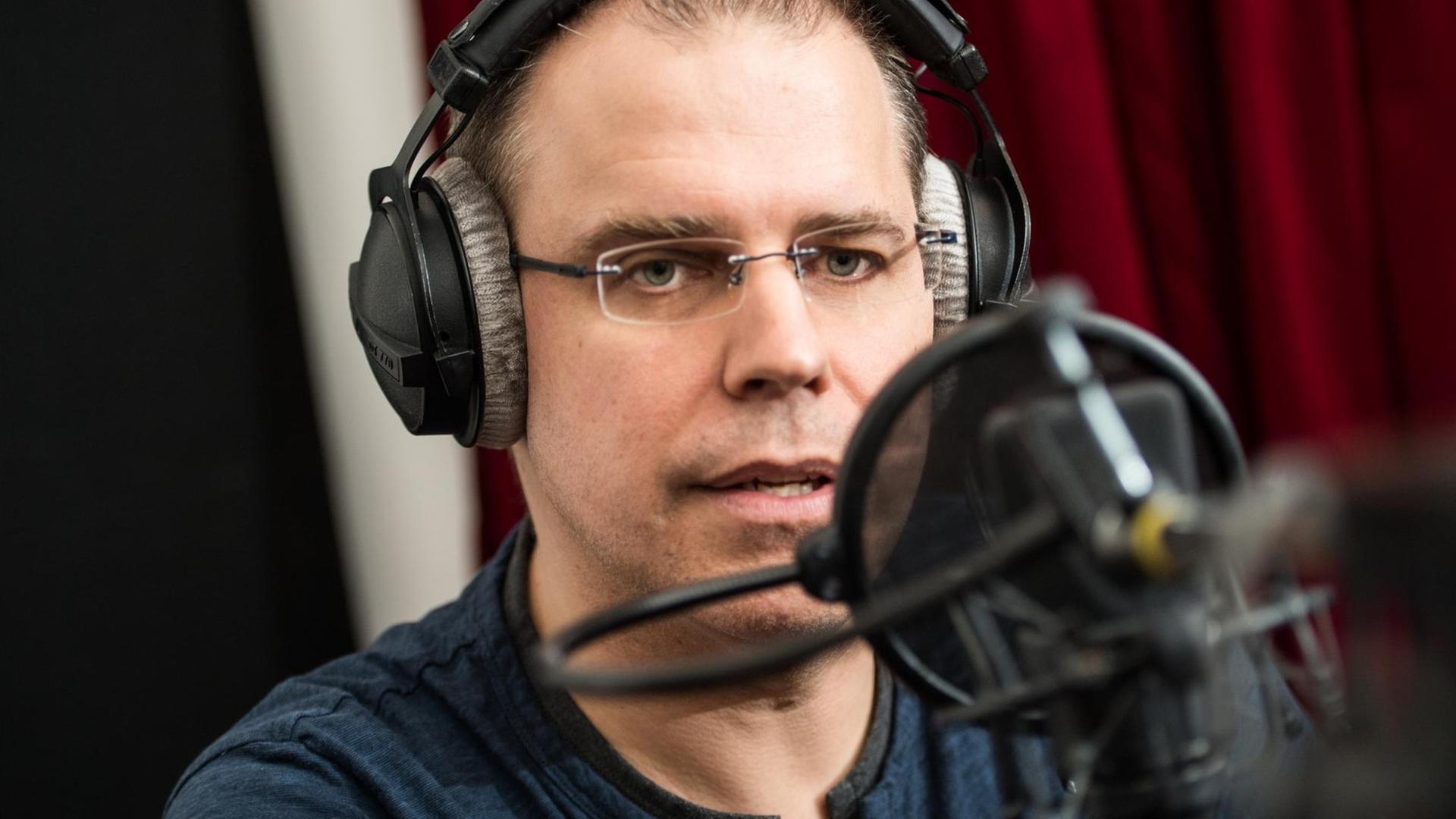 10.07.2019, Hessen, Frankfurt/Main: Heiko Grauel spricht in das Aufnahme-mikrofon. Heiko Grauel wurde im Rahmen eines Castings als neue Stimme für die Durchsagen in deutschen Bahnhöfen ausgewählt. 60 Stunden lang wurde Grauels Stimme aufgezeichnet. 10.07.2019, Hessen, Frankfurt/Main: Heiko Grauel spricht in das Aufnahme-mikrofon. Heiko Grauel wurde im Rahmen eines Castings als neue Stimme für die Durchsagen in deutschen Bahnhöfen ausgewählt. 60 Stunden lang wurde Grauels Stimme aufgezeichnet.