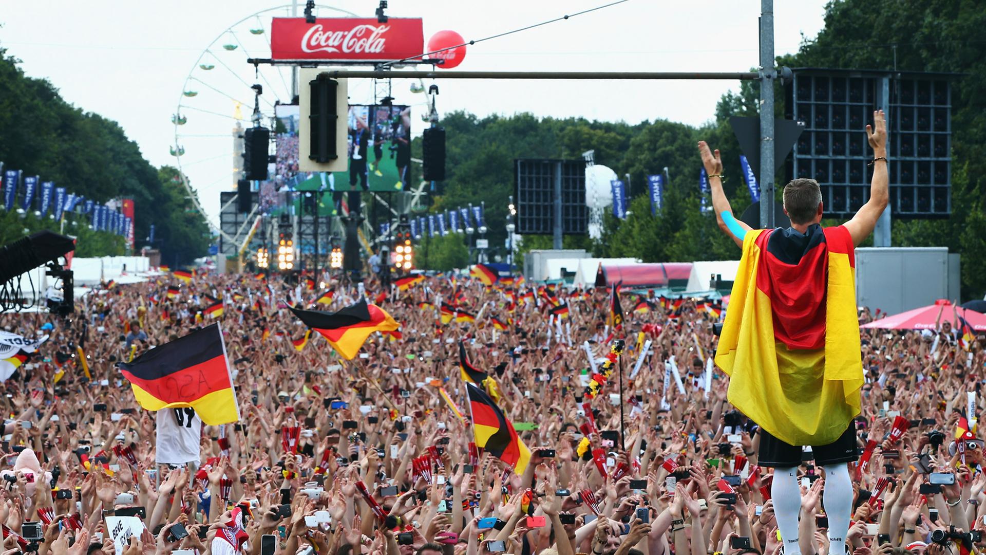 Bastian Schweinsteiger feiert mit Fans vor dem Brandenburger Tor in Berlin den Gewinn der Fußball-WM.