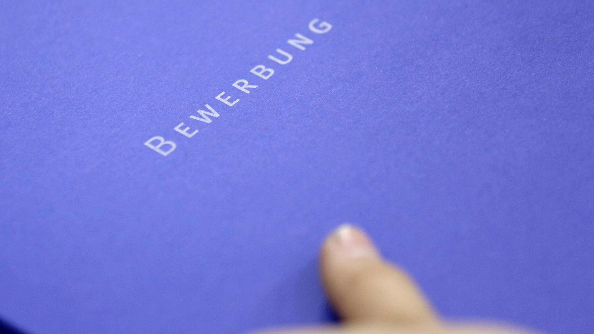Eine blaue Bewerbungsmappe mit dem Schriftzug Bewerbung Eine blaue Bewerbungsmappe mit dem Schriftzug Bewerbung