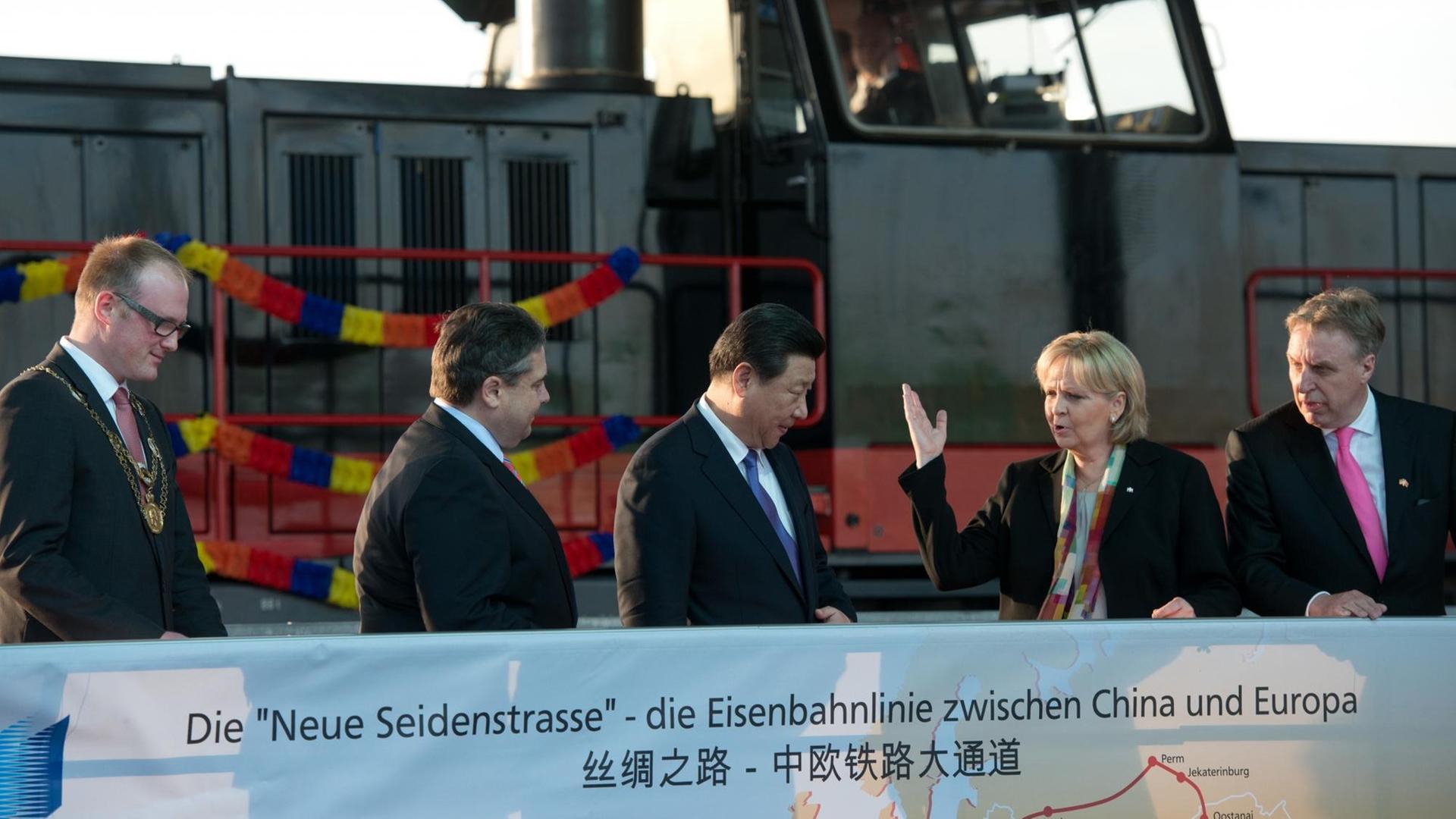Chinas Staats- und Parteichef Xi Jinping (M) steht in Duisburg (Nordrhein-Westfalen) zwischen Duisburgs Oberbürgermeister Sören Link, Bundeswirtschaftsminister Sigmar Gabriel, NRW-Ministerpräsidentin Hannelore Kraft und Erich Staake, Geschäftsführer des Duisburger Hafens Logport. Im Hintergrund ein gerade eingefahrener Zug aus China. Chinas Staats- und Parteichef Xi Jinping (M) steht in Duisburg (Nordrhein-Westfalen) zwischen Duisburgs Oberbürgermeister Sören Link, Bundeswirtschaftsminister Sigmar Gabriel, NRW-Ministerpräsidentin Hannelore Kraft und Erich Staake, Geschäftsführer des Duisburger Hafens Logport. Im Hintergrund ein gerade eingefahrener Zug aus China.