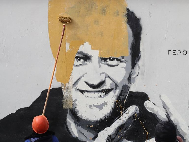 Ein Wandbild auf einem Gebäude in St. Petersburg, das den russischen Oppositionellen Alexej Nawalny zeigt mit dem Schriftzug "Der Held einer neuen Zeit", wird kurz nach seiner Entdeckung übermalt.