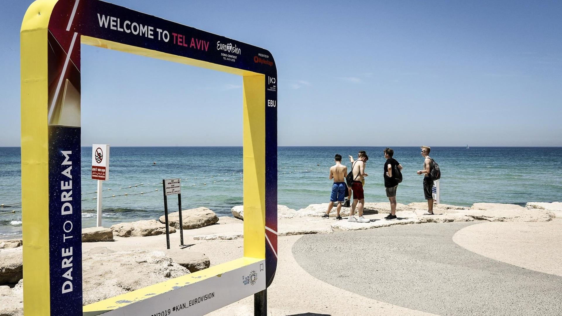 Touristen stehen mit Blick auf das Mittelmeer neben einem Werbeschild für den Eurovision Song Contest 2019. Vom 14. bis 18. Mai 2019 veranstaltet die Küstenstadt den internationalen Gesangswettbewerb Eurovision Song Contest (ESC) Touristen stehen mit Blick auf das Mittelmeer neben einem Werbeschild für den Eurovision Song Contest 2019. Vom 14. bis 18. Mai 2019 veranstaltet die Küstenstadt den internationalen Gesangswettbewerb Eurovision Song Contest (ESC)