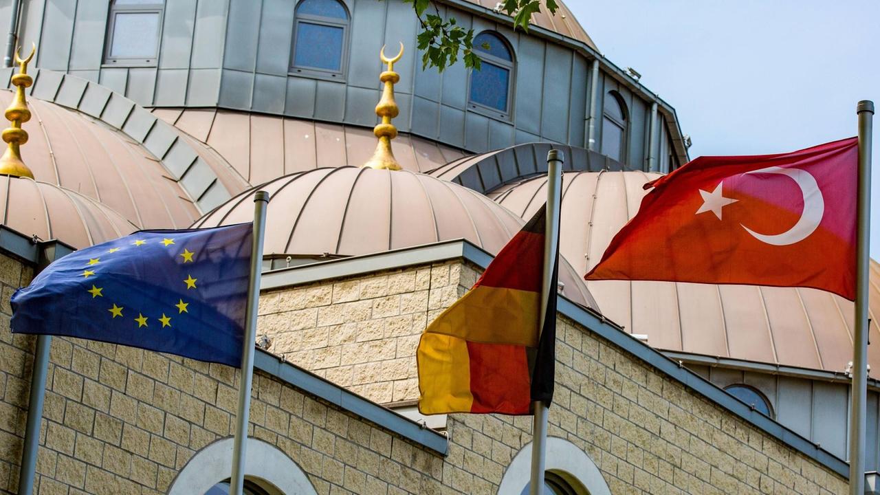 Wehende Fahnen der EU, Deutschlands und der Türkei vor der DITIB Moschee in Duisburg.
