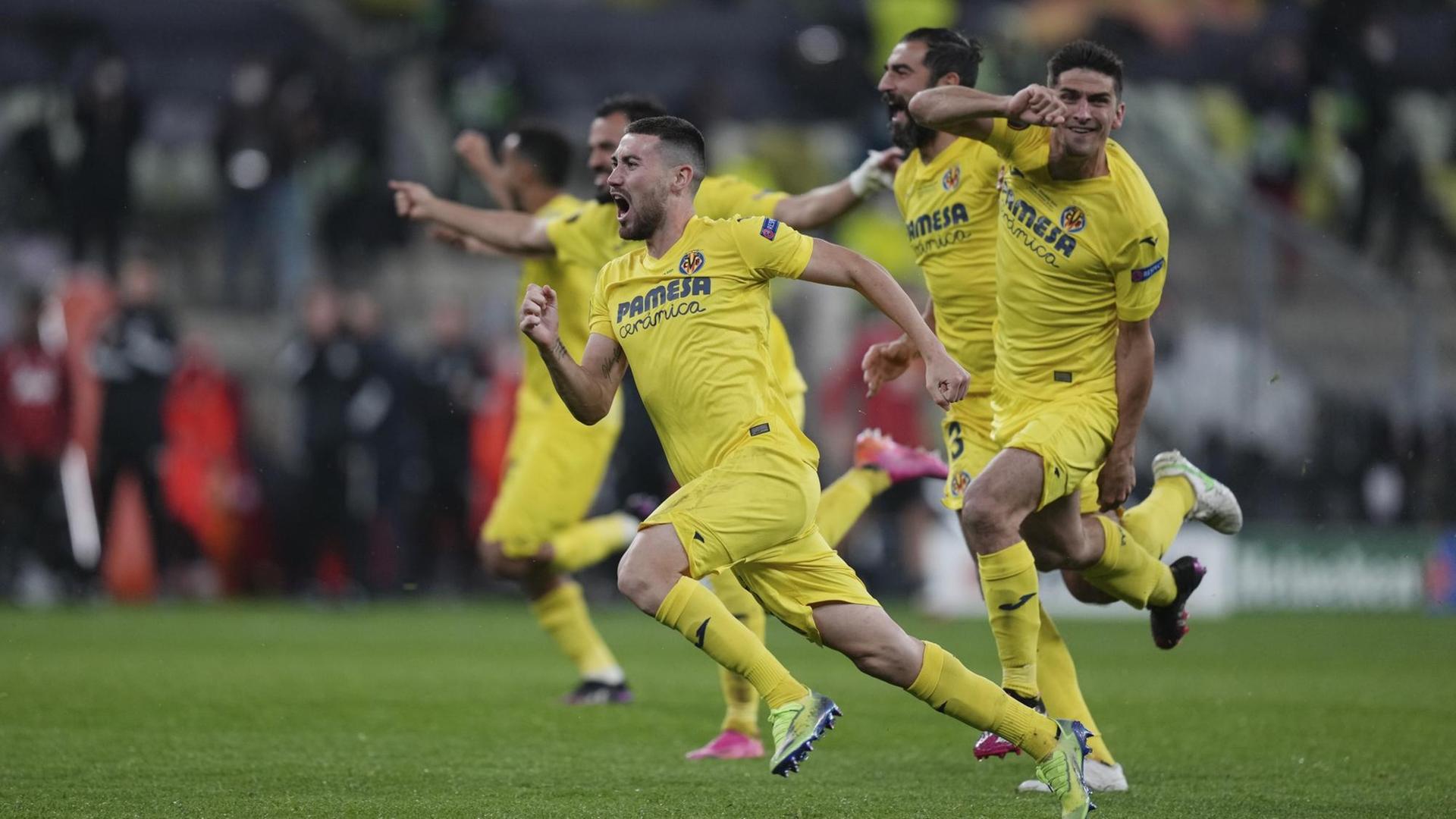 Spieler von dem Verein FC Villarreal laufen jubelnd über den Fußball-Platz. Spieler von dem Verein FC Villarreal laufen jubelnd über den Fußball-Platz.