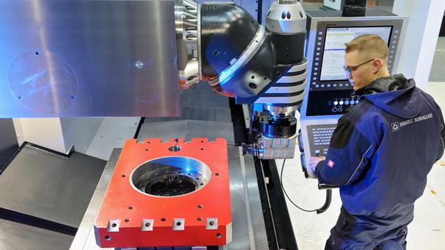 Ein Anwendungstechniker mit einer CNC-Fräsmaschine auf der Fachmesse "Intec" Foto: Jan Woitas/dpa-Zentralbild/dpa | Verwendung weltweit
