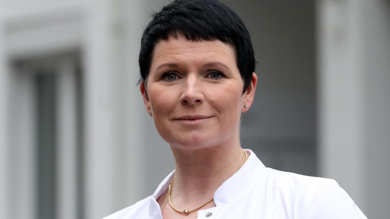 Die Ärztin Jördis Frommhold steht im weißen Kittel vor einem Klinikgebäude. Die Ärztin Jördis Frommhold steht im weißen Kittel vor einem Klinikgebäude.