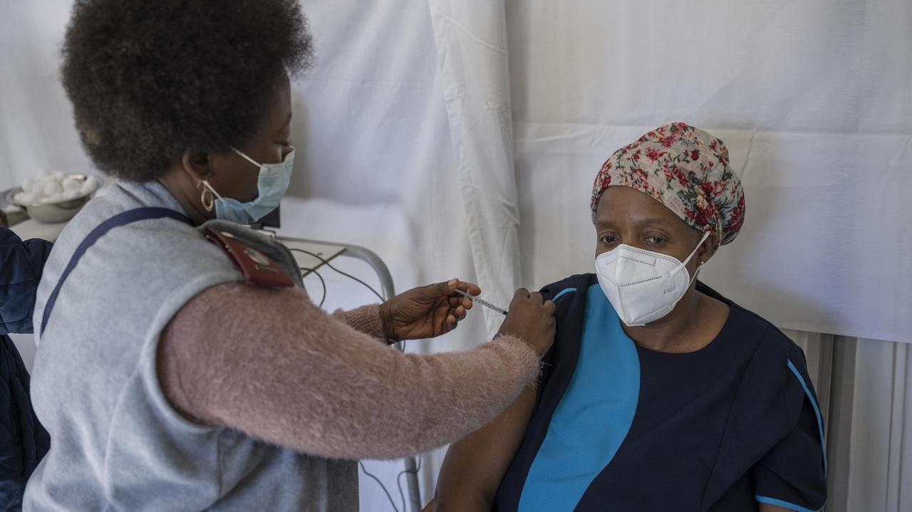 Eine Mitarbeiterin der Gesundheitsbehörde impft eine pflegebedürftige Person in einem Altenheim nahe Klerksdorp, Südafrika. Eine Mitarbeiterin der Gesundheitsbehörde impft eine pflegebedürftige Person in einem Altenheim nahe Klerksdorp, Südafrika.