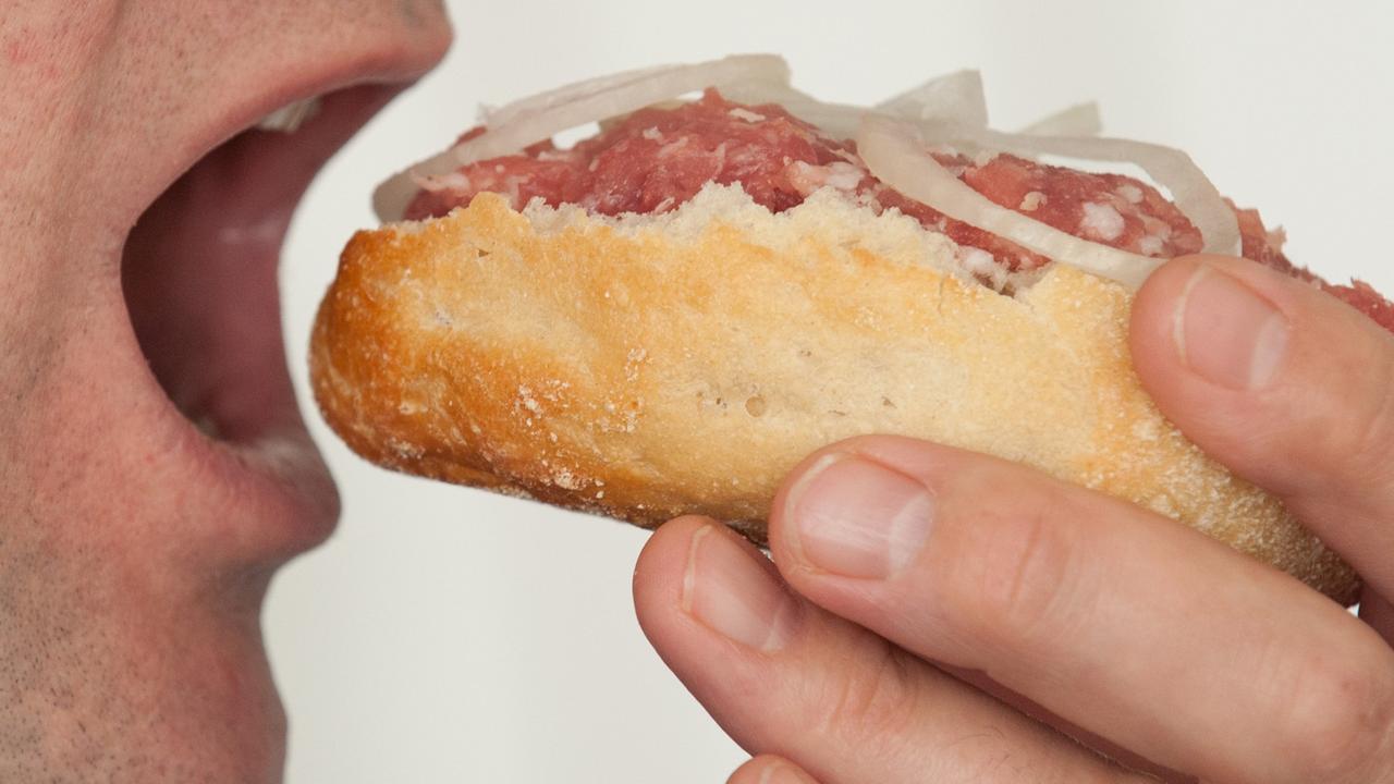 Ein Mann beißt in ein Mettbrötchen Ein Mann beißt in ein Mettbrötchen