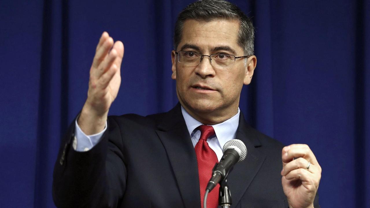 Xavier Becerra steht vor einem Mikrofon. Xavier Becerra steht vor einem Mikrofon.