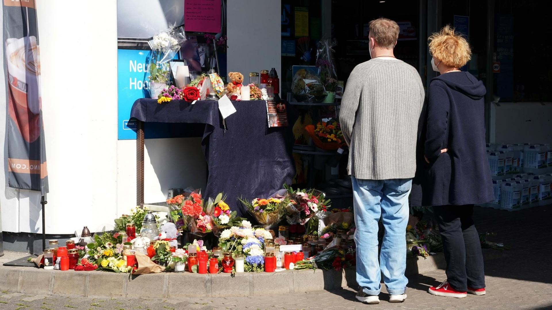Blumen, Kerzen und Botschaften an das Opfer liegen vor der Tankstelle, an der ein Maskengegner einen Angestellten erschossen hat. Zwei Menschen stehen vor den Blumen. Blumen, Kerzen und Botschaften an das Opfer liegen vor der Tankstelle, an der ein Maskengegner einen Angestellten erschossen hat. Zwei Menschen stehen vor den Blumen.