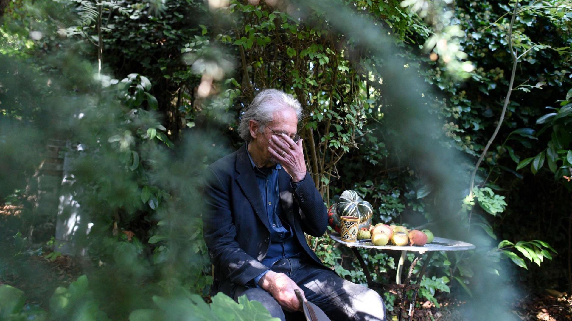 Der Autor Peter Handke in einem Garten mit der Hand vor den Augen Der Autor Peter Handke in einem Garten mit der Hand vor den Augen