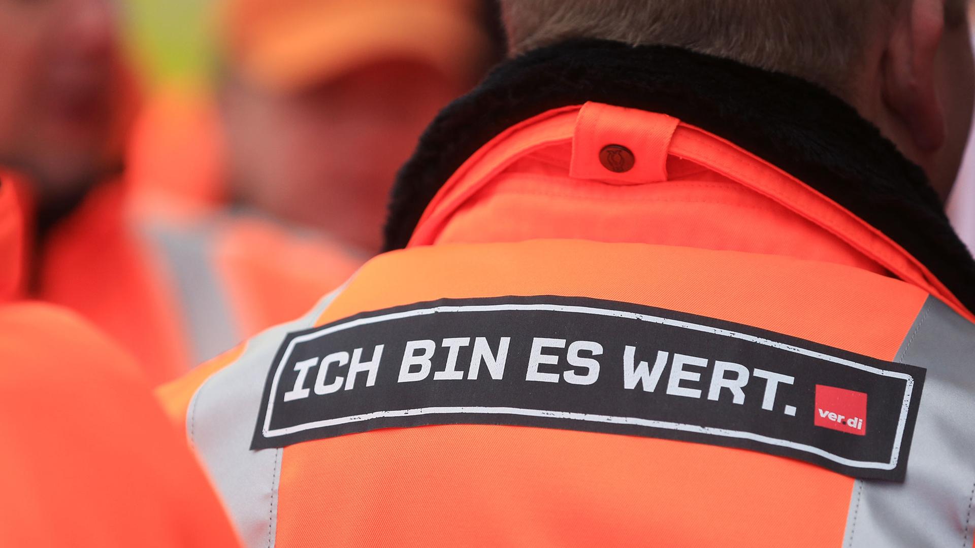 Ein Schriftzug "Ich bin es wert" ist auf dem Rücken eines verdi-Mitglieds zu sehen. Ein Schriftzug "Ich bin es wert" ist auf dem Rücken eines verdi-Mitglieds zu sehen.