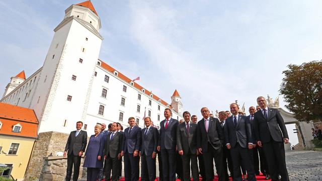 Die EU-Staats- und Regierungschefs stehen in mehreren Reihen auf einem roten Teppich zum Gruppenfoto bereit, im Hintergrund die Burg von Bratislava