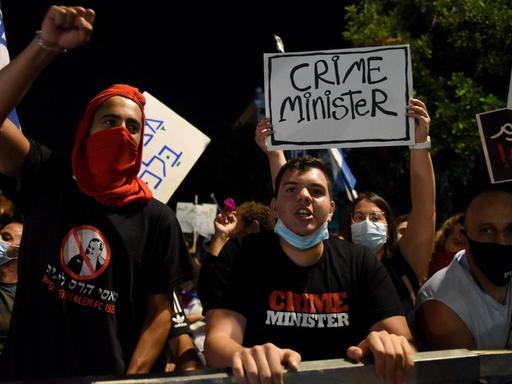 Parolen skandierende Aktivisten fordern lautstark den Rücktritt Netanjahus. Auf ihren T-Shirts bezeichnen den israelischen Premier als "Crime Minister".