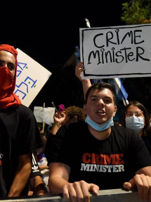 Parolen skandierende Aktivisten fordern lautstark den Rücktritt Netanjahus. Auf ihren T-Shirts bezeichnen den israelischen Premier als "Crime Minister".