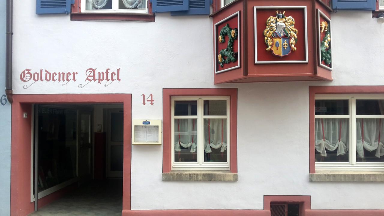 Fassade eines alten, renovierten Hauses auf dessen Fassade "Goldener Apfel" und die Hausnummer 14 steht. Fassade eines alten, renovierten Hauses auf dessen Fassade "Goldener Apfel" und die Hausnummer 14 steht.