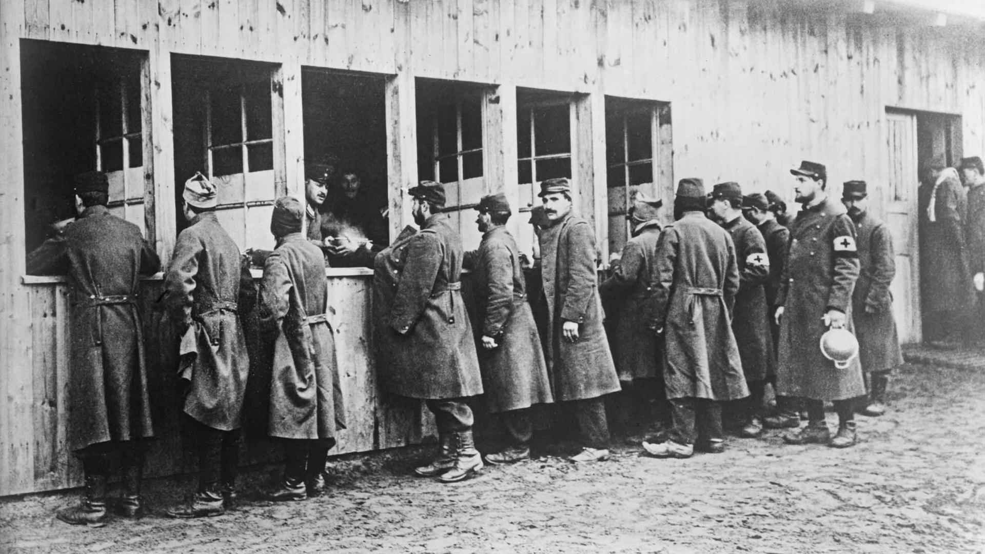 Kriegsgefangene im Ersten Weltkrieg stehen Schlange für ihre Essensrationen. Kriegsgefangene im Ersten Weltkrieg stehen Schlange für ihre Essensrationen.
