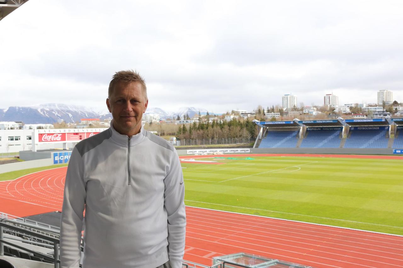 Heimir Hallgrímsson im Nationalstadion Laugardalsvöllur. Der Blick ist auf den Platz und die Tartanbahnen gerichtet. Im Hintergrund sind Berge. Heimir Hallgrímsson im Nationalstadion Laugardalsvöllur. Der Blick ist auf den Platz und die Tartanbahnen gerichtet. Im Hintergrund sind Berge.