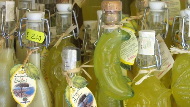 Das Angebot eines Souvenirgeschäftes in Sorrent von verschieden geformten Glasflaschen mit Limoncello, der Sorrentiner Spezialität, einem Likör aus Zitronen.