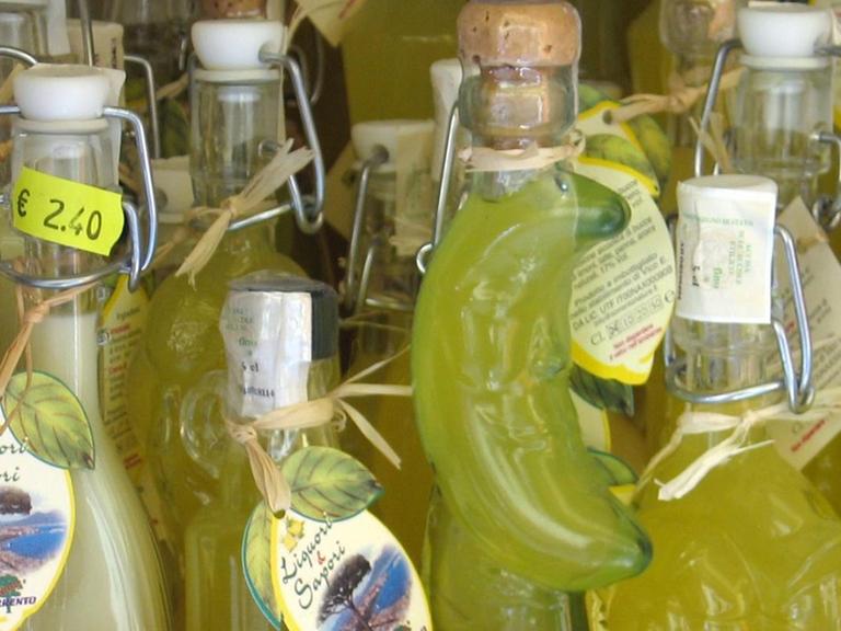 Das Angebot eines Souvenirgeschäftes in Sorrent von verschieden geformten Glasflaschen mit Limoncello, der Sorrentiner Spezialität, einem Likör aus Zitronen.