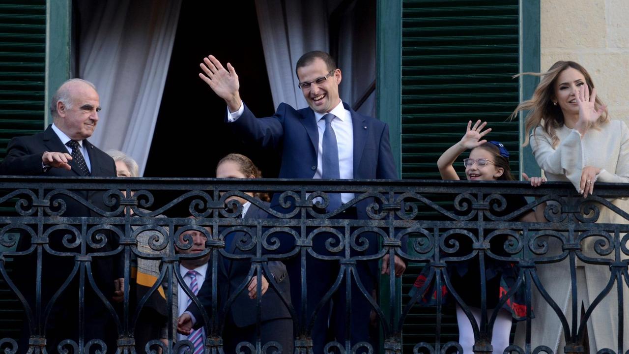 Im dunklen Anzug, weißem Hemd und Krawatte winkt Premierminister Robert Abela seinen Anhängern vom Balkon des Präsidentenpalastes in La Valetta zu.
