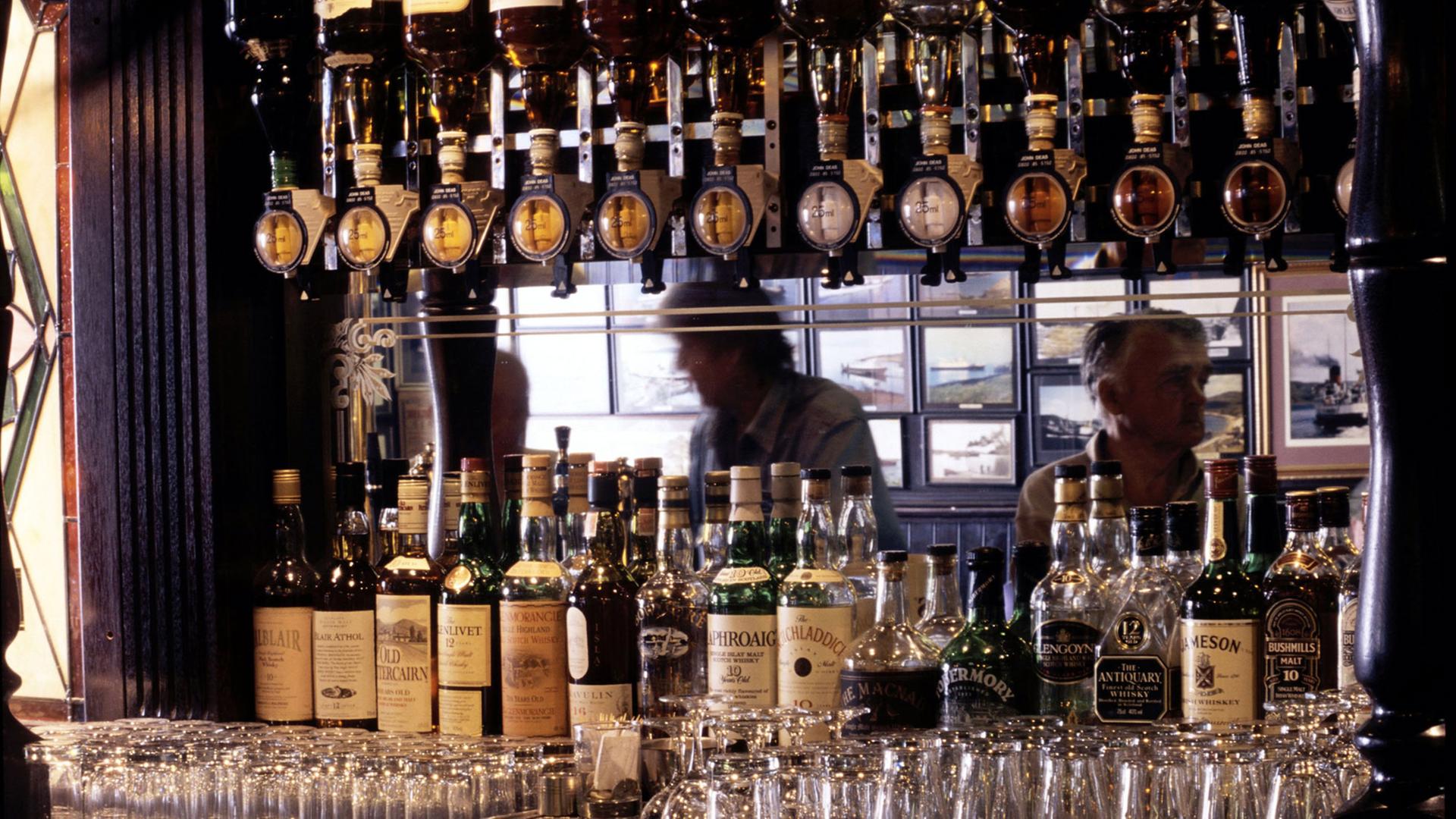 Die Whisky-Auswahl einer Bar in Oban in Schottland: Dutzende Whisky-Flaschen und zahlreiche Gläser sind zu sehen. Die Whisky-Auswahl einer Bar in Oban in Schottland: Dutzende Whisky-Flaschen und zahlreiche Gläser sind zu sehen.