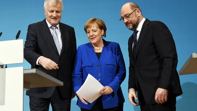 Der CSU-Vorsitzenden Horst Seehofer (l), der SPD-Parteivorsitzende Martin Schulz (r) und Bundeskanzlerin Angela Merkel (CDU) nehmen am 12.01.2018 im Willy-Brandt-Haus in Berlin an einer Pressekonferenz teil.