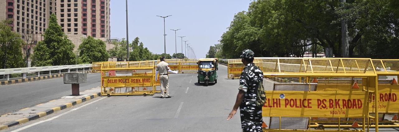 Bewaffnete Sicherheitskräfte kontrollieren Fahrzeuge an einer Straßensperre in Delhi Bewaffnete Sicherheitskräfte kontrollieren Fahrzeuge an einer Straßensperre in Delhi