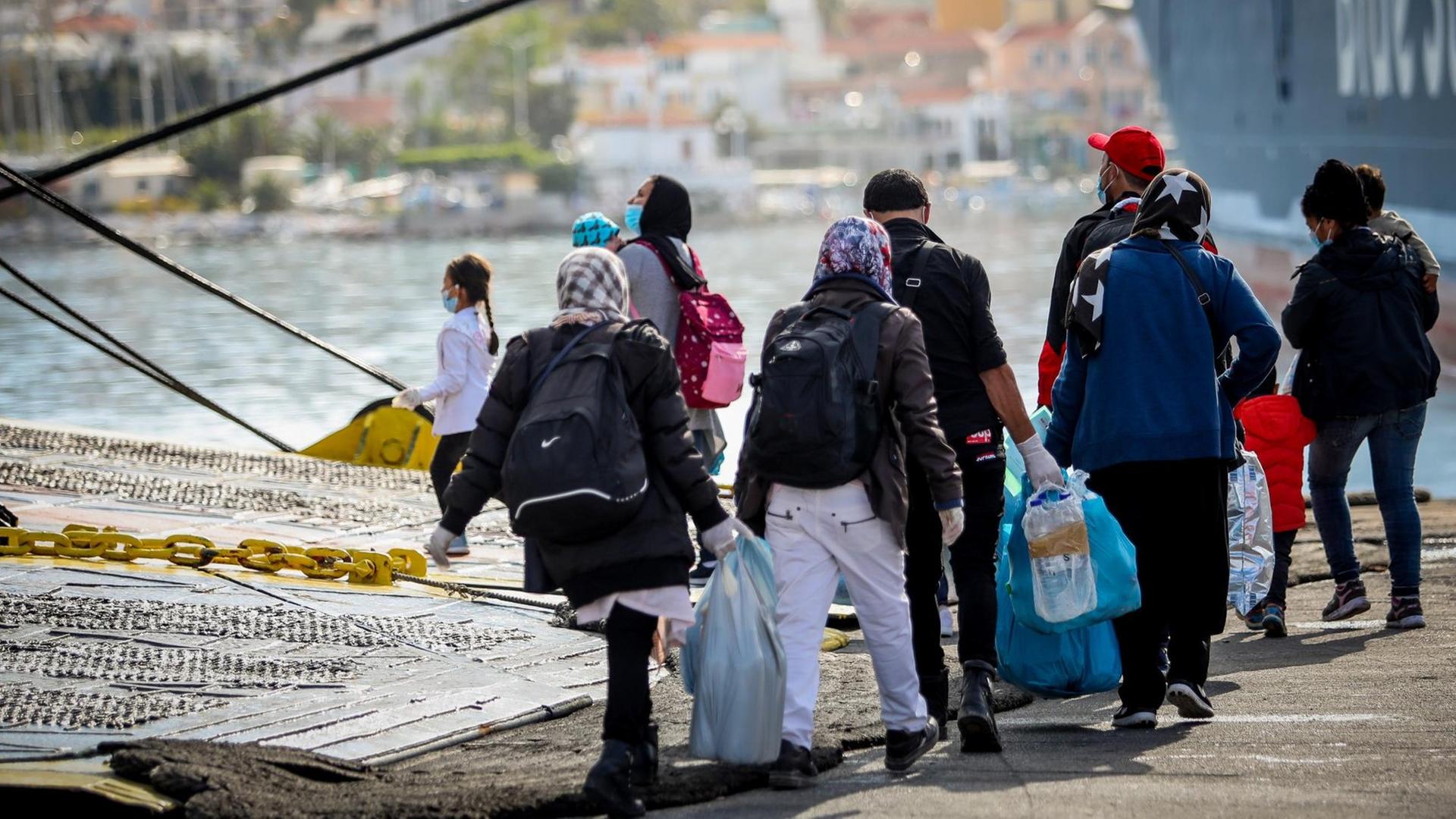 Migranten gehen an Bord einer Fähre, die sie vom völlig überfüllten Flüchtlingslager Moria auf der griechischen Insel Lesbos nach Piräus brachte, von wo sie mit Bussen zu Aufnahmelagern auf dem griechischen Festland gebracht wurden. Migranten gehen an Bord einer Fähre, die sie vom völlig überfüllten Flüchtlingslager Moria auf der griechischen Insel Lesbos nach Piräus brachte, von wo sie mit Bussen zu Aufnahmelagern auf dem griechischen Festland gebracht wurden.