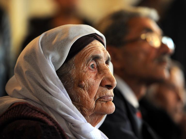 Die 107 Jahre alte Syrerin Sabria Khalaf sitzt am 17.03.2014 zusammen mit ihrem Sohn Kanan Ali auf dem Sofa ihrer Familie in Holdorf (Niedersachsen).
