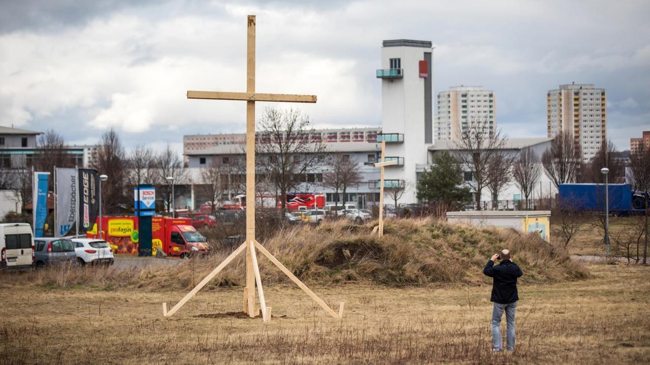 Eine Mann fotografiert in Erfurt (Thüringen) Mit einem großen Holzkreuz auf einem Grundstück in der Nähe der als Baugrund für den Moschee-Neubau vorgesehenen Fläche protestiert das Bündnis "Bürger für Erfurt" gegen die Moscheebaupläne in Erfurt-Marbach protestieren. Foto: Arifoto Ug/dpa-Zentralbild/dpa | Verwendung weltweit Eine Mann fotografiert in Erfurt (Thüringen) Mit einem großen Holzkreuz auf einem Grundstück in der Nähe der als Baugrund für den Moschee-Neubau vorgesehenen Fläche protestiert das Bündnis "Bürger für Erfurt" gegen die Moscheebaupläne in Erfurt-Marbach protestieren. Foto: Arifoto Ug/dpa-Zentralbild/dpa | Verwendung weltweit