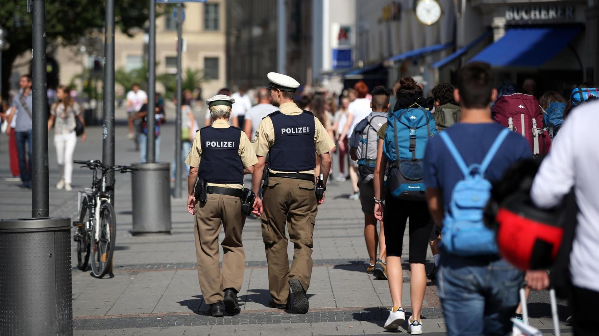 Zwei Polizisten gehen durch die Münchner Fußgängerzone. Zwei Polizisten gehen durch die Münchner Fußgängerzone.