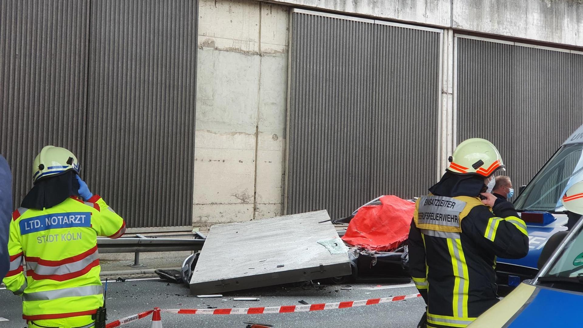 Ein Beton-Teil von einer Lärm-Schutz-Wand liegt auf einem Auto. Ein Beton-Teil von einer Lärm-Schutz-Wand liegt auf einem Auto.