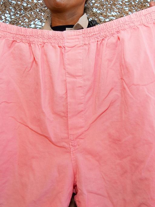 Eine Frau hält eine rosafarbene Boxershort, die Gefangene in einem US-Gefängnis tragen müssen.