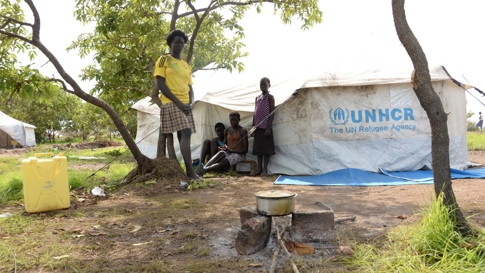Die 17-jährige Christine aus dem Südsudan steht mit ihren Schwestern neben ihrer Hütte in der Imvepi-Flüchtlingssiedlung im Nordwesten Ugandas. Die 17-jährige Christine aus dem Südsudan steht mit ihren Schwestern neben ihrer Hütte in der Imvepi-Flüchtlingssiedlung im Nordwesten Ugandas.