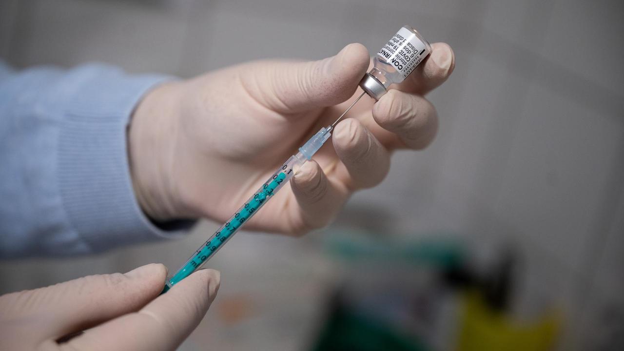Ein Arzt zieht in einer Hausarztpraxis eine Spritze mit dem Impfstoff von Pfizer/Biontech auf. Ein Arzt zieht in einer Hausarztpraxis eine Spritze mit dem Impfstoff von Pfizer/Biontech auf.