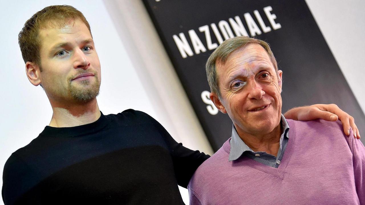 Schwazer steht neben Donati und hat seinen Arm um ihn gelegt. Schwazer steht neben Donati und hat seinen Arm um ihn gelegt.