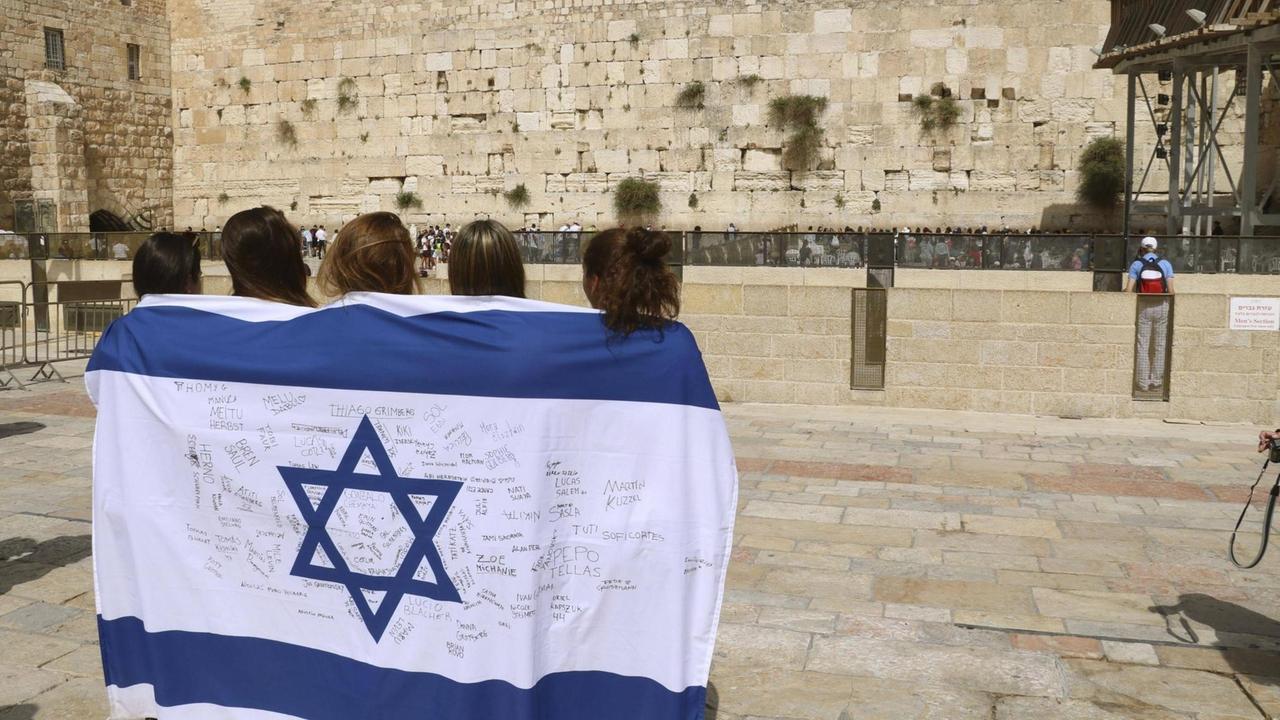 Junge Menschen stehen wegen des 70. Gründungsjubiläums mit einer Israel-Fahne in der Altstadt von Jerusalem. Junge Menschen stehen wegen des 70. Gründungsjubiläums mit einer Israel-Fahne in der Altstadt von Jerusalem.