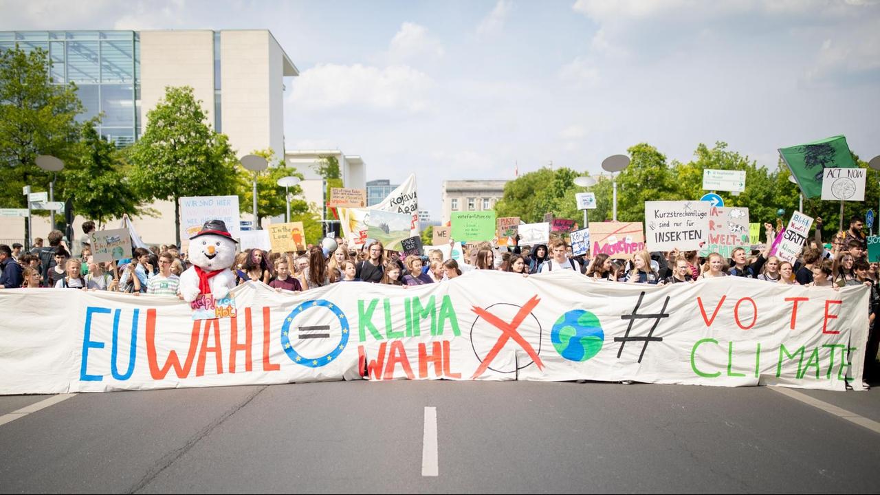 Im Vordergrund Schülerinnen und Schüler die einen großen Banner mit der Aufschrift "EU Wahl gleich Klimawahl" tragen. Im Hintergrund unzählige Schülerinnen und Schüler mit Transparenten. Im Vordergrund Schülerinnen und Schüler die einen großen Banner mit der Aufschrift "EU Wahl gleich Klimawahl" tragen. Im Hintergrund unzählige Schülerinnen und Schüler mit Transparenten.