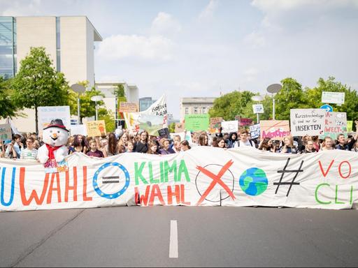 Im Vordergrund Schülerinnen und Schüler die einen großen Banner mit der Aufschrift "EU Wahl gleich Klimawahl" tragen. Im Hintergrund unzählige Schülerinnen und Schüler mit Transparenten.